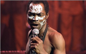 Fela Kuti on stage, ochre backdrop